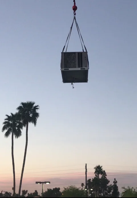 Packaged equipment in transit during a rooftop lift.