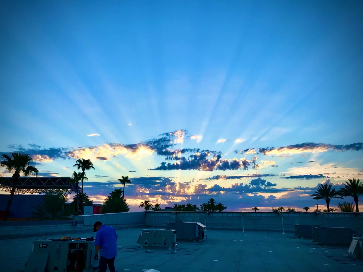 Commercial rooftop HVAC service work under a sunrise sky